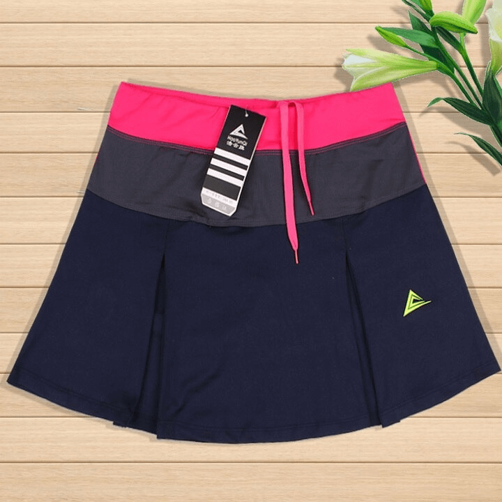 Women's breathable navy tennis skirt-shorts with pocket, featuring a pink waistband and durable anti-pilling fabric, ideal for sports.